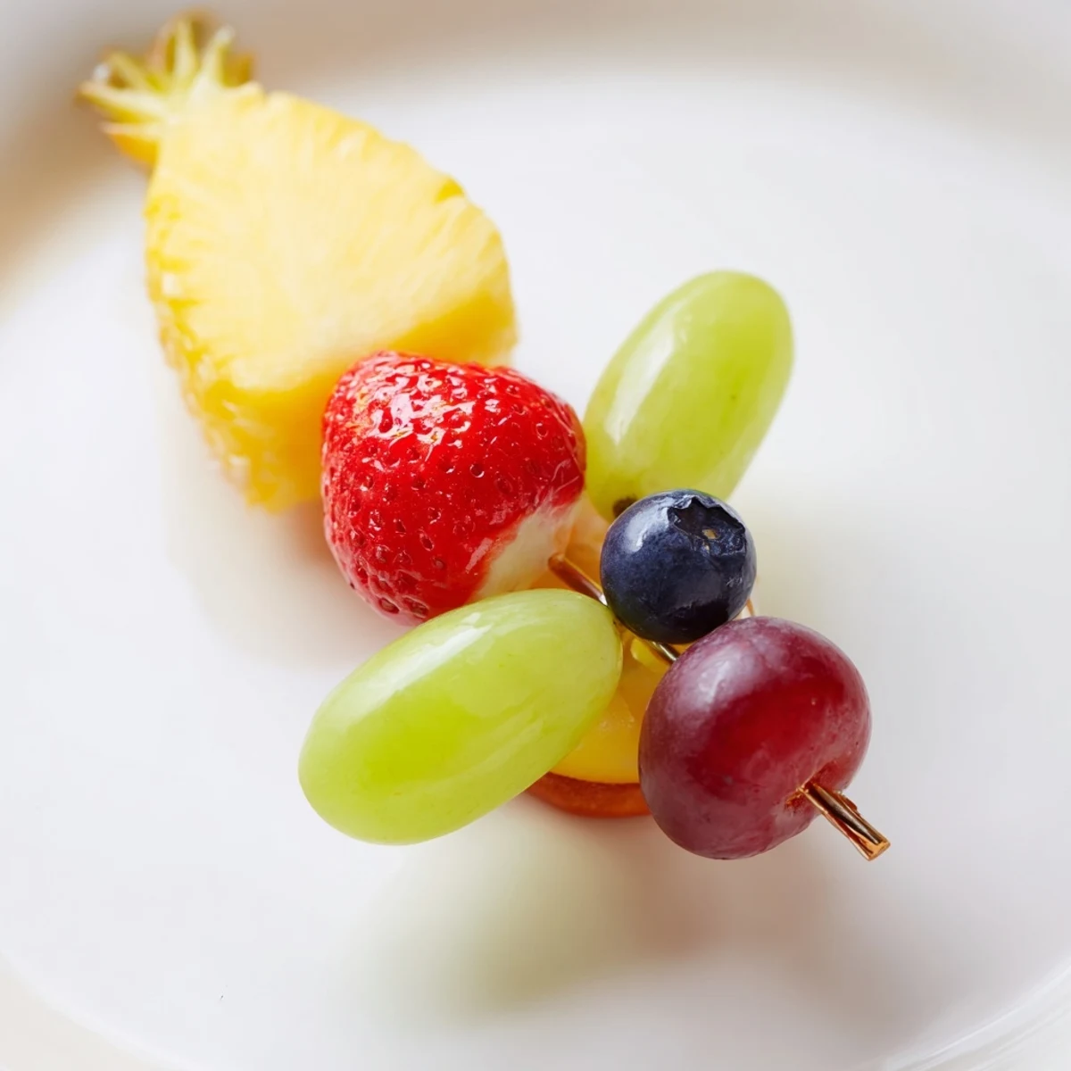 Vibrant Christmas Light Fruit Skewers displaying colorful fruit glistening under a soft light before serving.