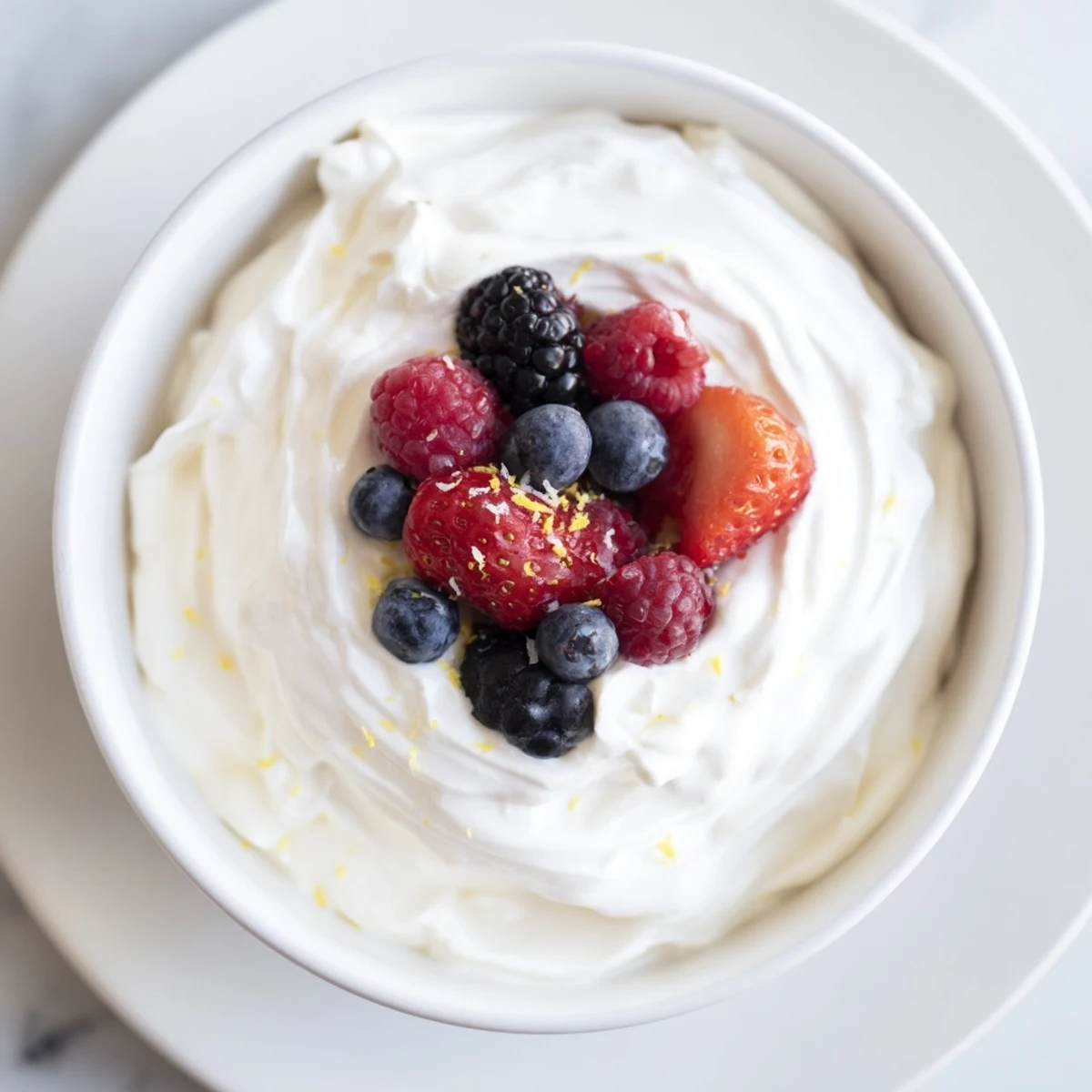 Fresh berries and fluffy cream cheese fruit dip: a delightful party snack with vibrant colors.