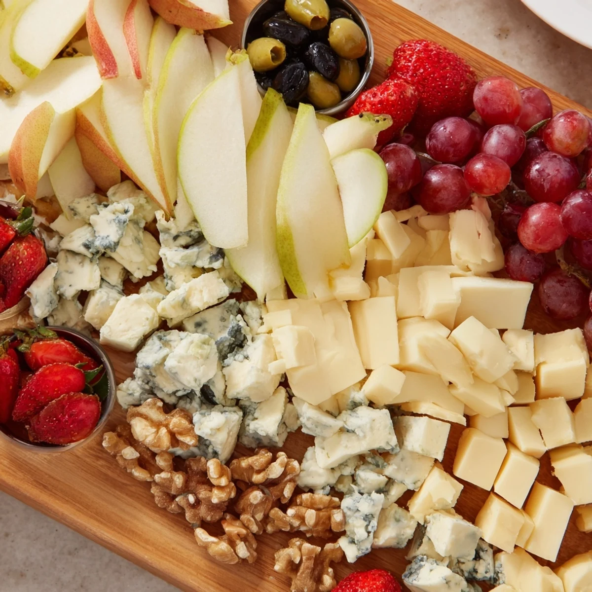 Waterfall Edge Grazing Board spilling over with cheeses, fruits, and crackers for a delightful party appetizer.