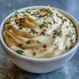 Homemade garlic aioli in a rustic bowl, showcasing its rich, velvety texture and fresh garlic aroma.  