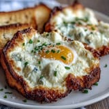 Whipped egg whites baked into cloud-like mounds with runny yolks, topped with fresh herbs for brunch.  
