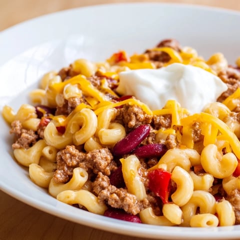 A steaming bowl of one-pot chili mac with melted cheese and ready to eat.
