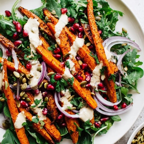 Vibrant Roasted Carrot Salad with tahini-lemon drizzle, showing caramelized carrots and fresh greens.