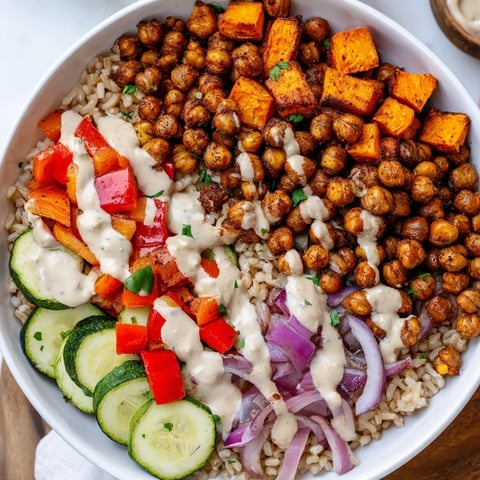 A colorful Roasted Chickpea Buddha Bowl with crispy chickpeas, roasted veggies, rice and tahini dressing.