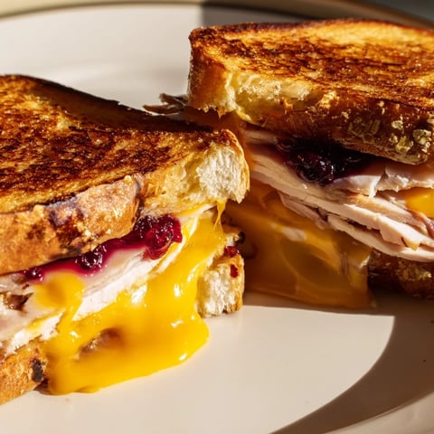 Smoked Turkey Grilled Cheese sandwich with melted cheddar and cranberry spread on golden toasted bread.