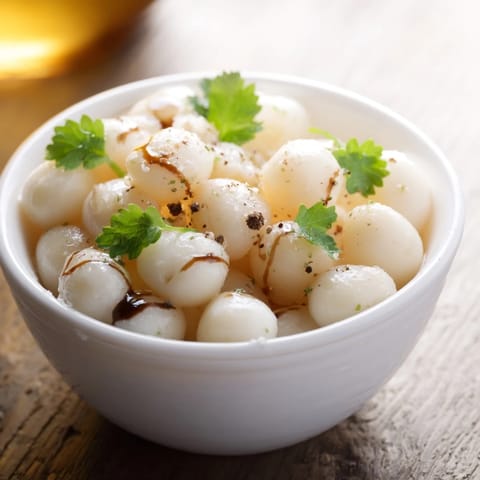 Fresh mozzarella pearls glistening with olive oil, seasoned for a quick, delicious snack or appetizer.