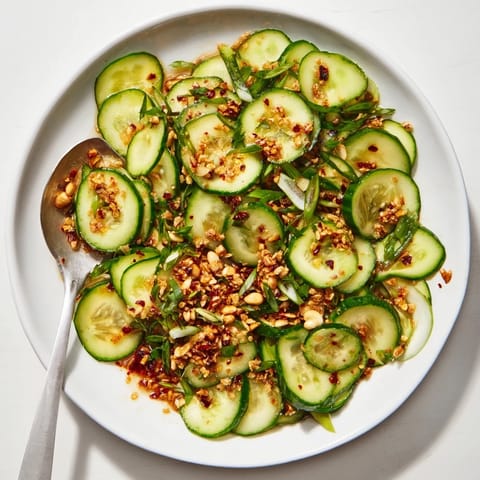 Close-up of the refreshing Cucumber Shaker Salad, ready to serve with a spicy chili crisp topping.