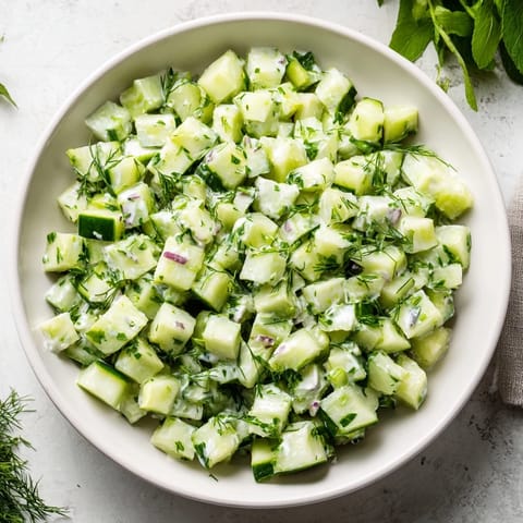 A vibrant bowl of Cucumber and Greek Yogurt Tzatziki Salad with diced cucumbers and red onion.