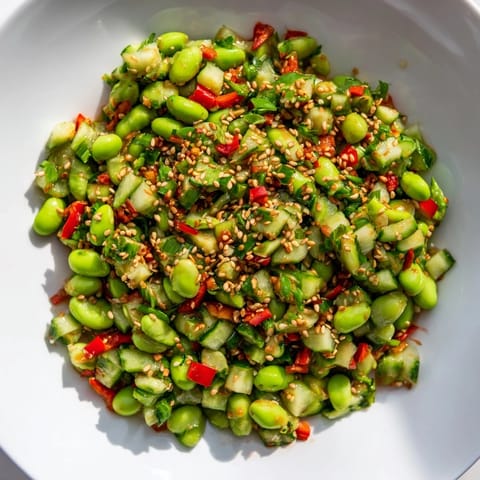 Chilled edamame salad overflowing with fresh veggies and a savory Asian-inspired dressing, ideal side.
