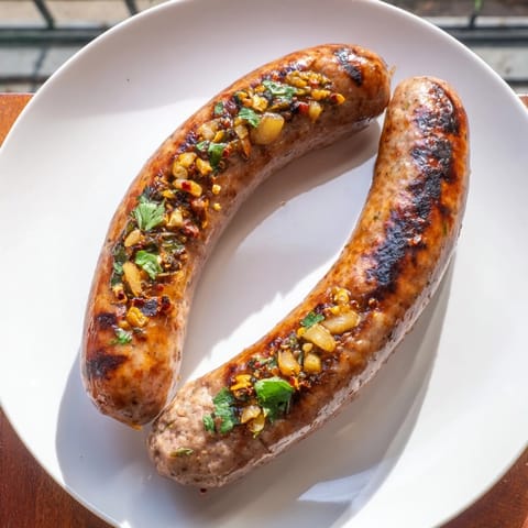 A close-up of perfectly cooked Tunisian Merguez, displaying a rustic, flavorful texture and inviting aroma.
