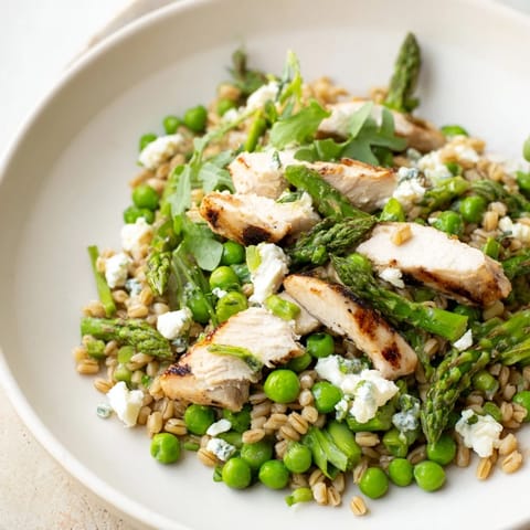 Warm Spring Farro Chicken Salad features tender grains and sliced chicken tossed with crisp asparagus and peas.