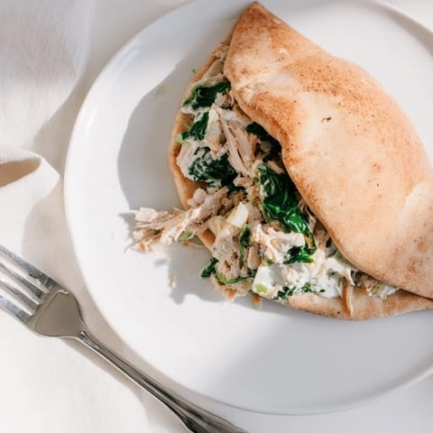 Fluffy pita pockets stuffed with creamy spinach artichoke chicken, baked until golden and melty.  