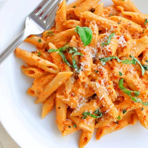 Weeknight creamy roasted red pepper pasta paired with a crisp green salad and garlic bread.
