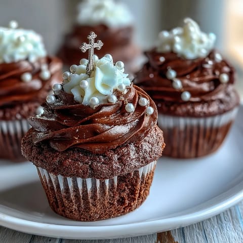 Mini First Communion Cupcakes with Rosary Fondant Toppers on a white plate, each topped with creamy vanilla buttercream and delicate fondant rosary, perfect for religious celebrations.