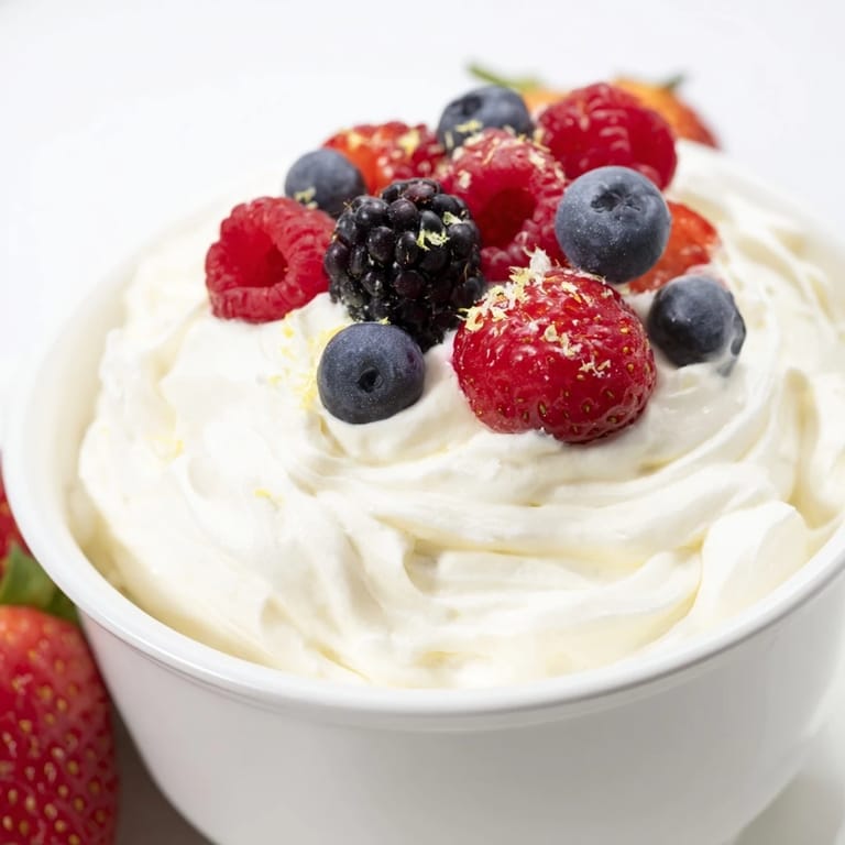 Tangy and sweet: a bowl of the irresistible, homemade fluffy cream cheese fruit dip, ready to eat.