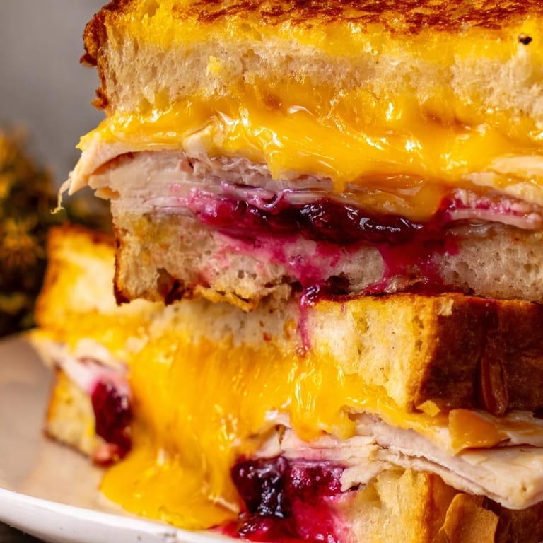 Warm Smoked Turkey Grilled Cheese sliced to show gooey cheese and savory turkey layers.