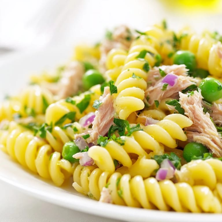 Zesty Lemony Tuna Pasta Salad tossed with olive oil, red onion, and fresh parsley, perfect for a summer picnic or potluck.